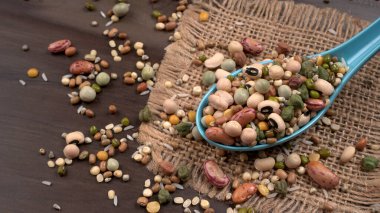 Ahşap arka planda çeşitli fasulye yığınları. Sağlıklı gıda konsepti