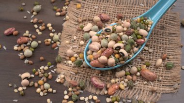 Ahşap arka planda çeşitli fasulye yığınları. Sağlıklı gıda konsepti