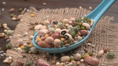 Ahşap arka planda çeşitli fasulye yığınları. Sağlıklı gıda konsepti