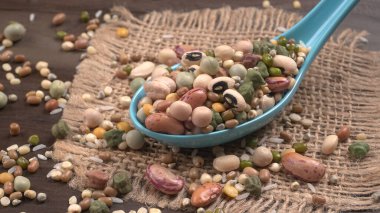 Ahşap arka planda çeşitli fasulye yığınları. Sağlıklı gıda konsepti