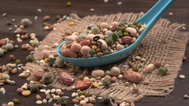 Ahşap arka planda çeşitli fasulye yığınları. Sağlıklı gıda konsepti