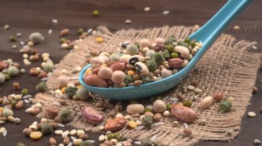 Ahşap arka planda çeşitli fasulye yığınları. Sağlıklı gıda konsepti