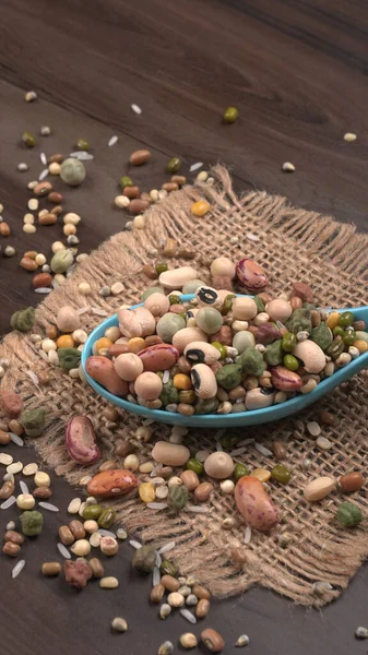 Ahşap arka planda çeşitli fasulye yığınları. Sağlıklı gıda konsepti