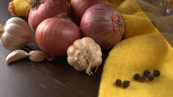 Red Onions Garlic Black Peppers Dark Wooden Table Yellow Towel — Stock Photo, Image