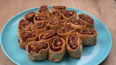 Ahşap zemin üzerinde tatlı hamur işleri olan tabağın yakın çekimi 