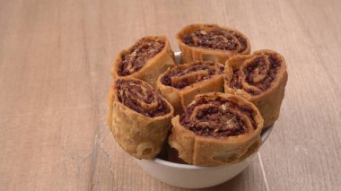 Ahşap zemin üzerinde tatlı hamur işleri olan tabağın yakın çekimi 