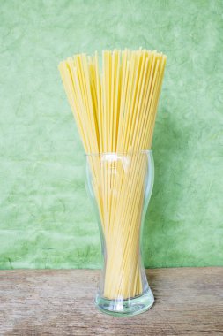 Bir cam uzmanlık yeşil bir arka plan üzerine yerleştirilen satır spagetti