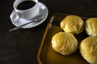 Ekmek ekmek ve bir tabak içinde siyah kahve.