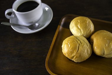 Ekmek ekmek ve bir tabak içinde siyah kahve.