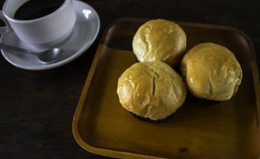 Ekmek ekmek ve bir tabak içinde siyah kahve.