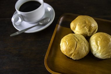 Ekmek ekmek ve bir tabak içinde siyah kahve.