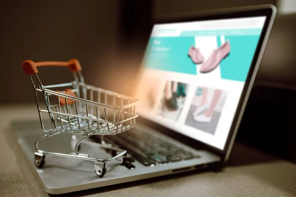 Dizüstü bilgisayarda alışveriş arabası var. İnternetten alışveriş veya e-ticaret fikirleri.
