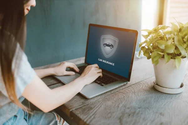 Güzel kız evde internetten araba sigortası için dizüstü bilgisayar kullanıyor..
