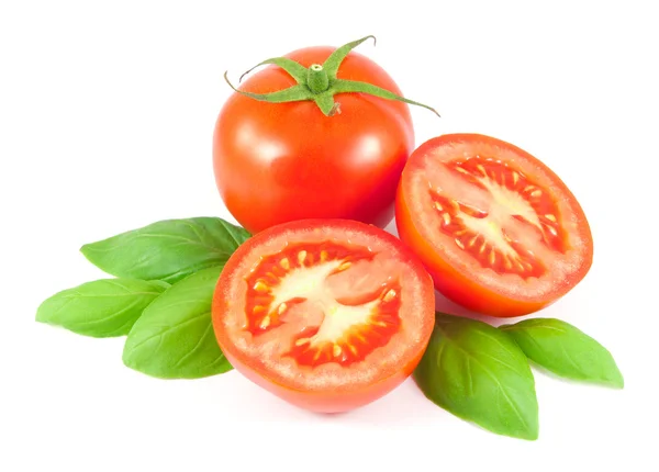 Bütün ve dilimlenmiş domates fesleğen yaprakları üzerinde beyaz izole ile