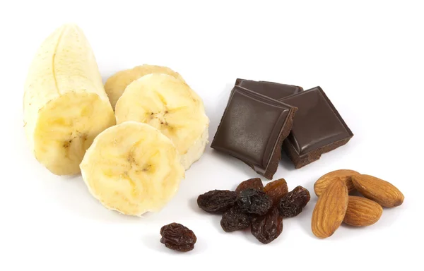 Soyulmuş dilimlenmiş muz çikolata, badem ve beyaz zemin üzerine kuru üzüm ile