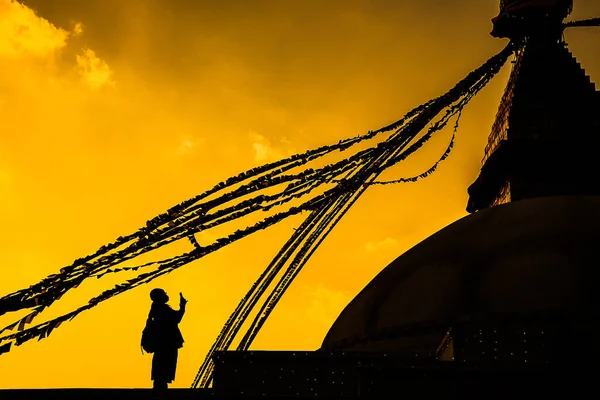 This a silhouette of a person taking photo near a stupa in Kathmandu, Nepal.