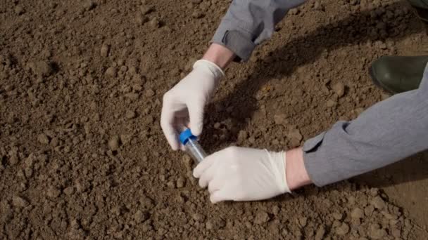 化学的研究を目的として研究室管に土の塊をつかむ農学者の手 — ストック動画