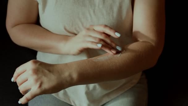 Молода жінка наносить зволожуючий крем на шкіру зап'ястя, крупним планом знімає догляд за жіночими руками — стокове відео