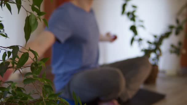 Concentration floue d'un jeune homme indéfini assis sur un tapis de yoga et respirant dans la pratique de la méditation à la maison — Video