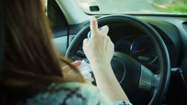 Женщина распыляет дезинфицирующее средство и очищает руль влажными салфетками — стоковое видео