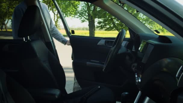 Hombre subiendo al coche, poniéndose el cinturón de seguridad y acercándose a la llave de los coches — Vídeos de Stock