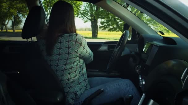 Een vrouw in een auto die haar gordel omdoet en begint te rijden. — Stockvideo