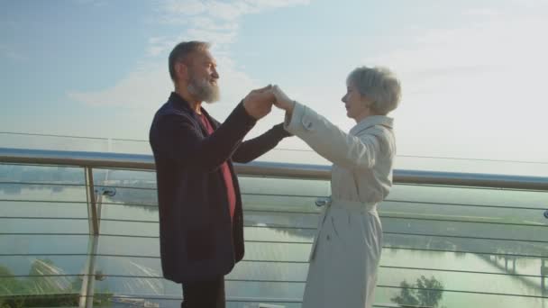 上了年纪的夫妻在观景台上跳舞，在阳光的照耀下 — 图库视频影像