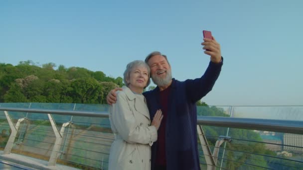 Lächelnder alter Mann hält Smartphone in der Hand und macht Selfie mit Ehefrau — Stockvideo