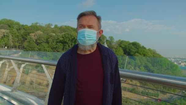 Elderly vaccinated man putting off mask and enjoying fresh air — Stock Video