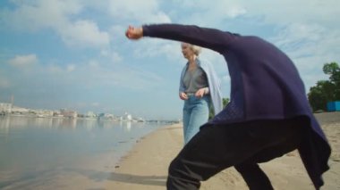 Son sınıflar nehir veya göl kıyısında çakıl taşlarını suya atarken eğleniyorlar.