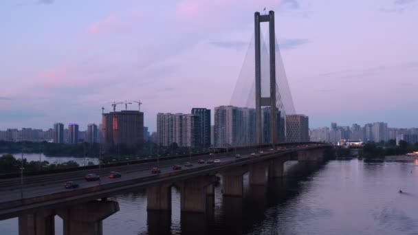 Tráfego urbano sobre ponte fluvial com edifícios e guindastes em segundo plano — Vídeo de Stock