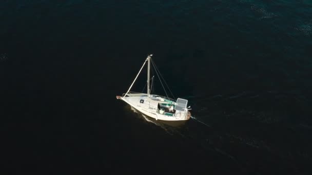 Letecký pohled na jachtu se solárními panely plachtění moře nebo řeky při východu slunce — Stock video