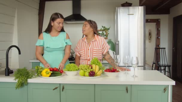 Многонациональные девушки готовят здоровую пищу и приветствуют азиатского друга — стоковое видео