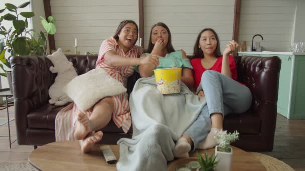 Diversas mujeres viendo comedia en la televisión, riendo, comiendo palomitas de maíz en casa — Vídeo de stock