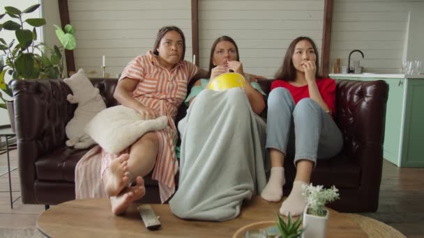 Groupe de femmes multiculturelles regarder thriller sur la télévision numérique à la maison — Video