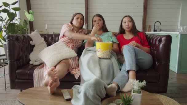 Diversas amigas comiendo palomitas de maíz y viendo películas en la televisión en casa — Vídeos de Stock