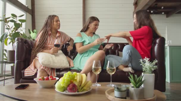 Support and jealousy between three mixed race female friends indoors — Stock Video