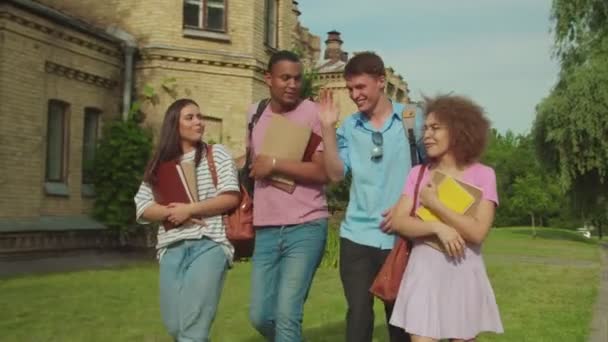 Diverse group of students walking along university building outdoors — Vídeo de Stock