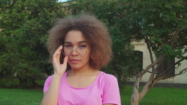 Close-up portret van tiener gemengd ras meisje in bril buitenshuis — Stockvideo