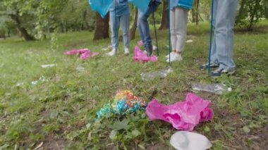 Dağınık plastik çöplere ve arka plandaki gönüllülere yakın çekim
