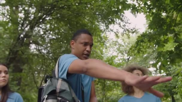 Activista respetuoso con el medio ambiente dando instrucciones al equipo al aire libre — Vídeo de stock