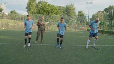 Futbolcular güneş doğarken açık havada spor yapıyorlar.