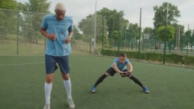 Futbolcular külahlarla top sürme egzersizi yapıyorlar.