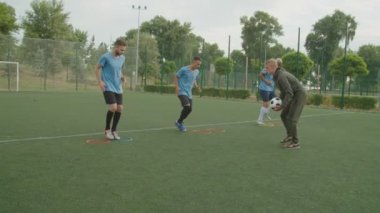 Futbolcular dışarıda çeviklik hız çemberleriyle egzersiz yapıyorlar.