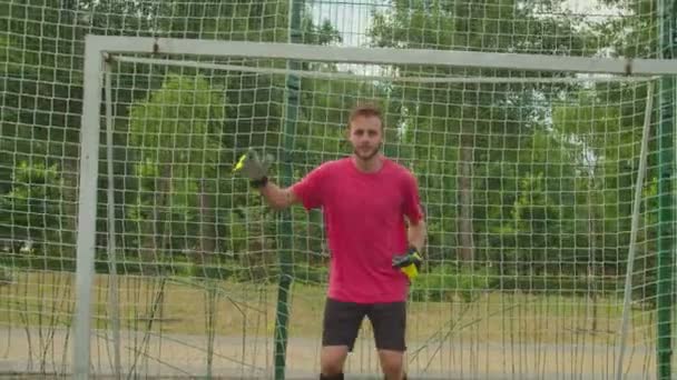 Футбольний бородатий воротар практикує захист футбольних цілей на відкритому повітрі — стокове відео