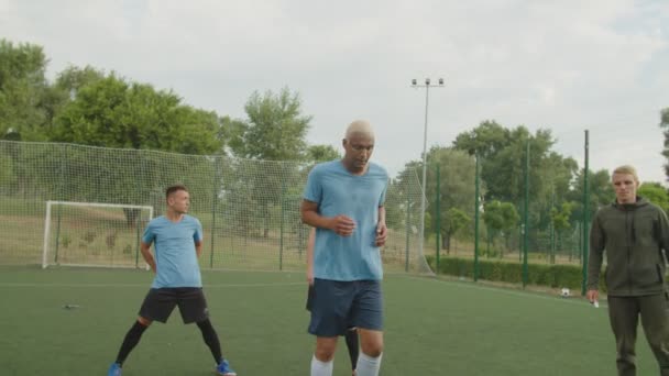 Jogador de futebol saltando barreiras, realizando exercícios de driblagem ao ar livre — Vídeo de Stock