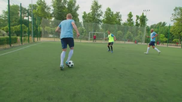 Geschoolde verdediger doet glijdende tackle in onder stakers voeten buiten — Stockvideo