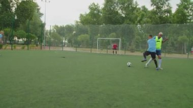 Futbolcu defans oyuncusunu yeniyor, şafakta dışarıda gol atıyor.