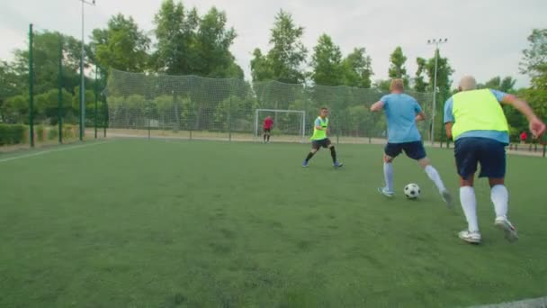 Voetbalstaker doet trucs, slaat verdedigers, scoort doelpunt buiten — Stockvideo