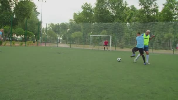 Delantero de fútbol batir defensor de fútbol, anotando gol al aire libre al amanecer — Vídeo de stock
